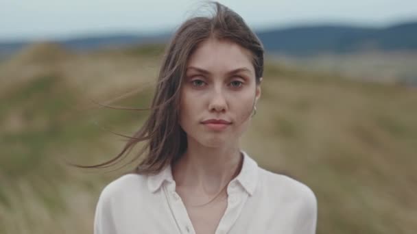 Портрет женщины с каштановыми волосами, позирующей на холме — стоковое видео