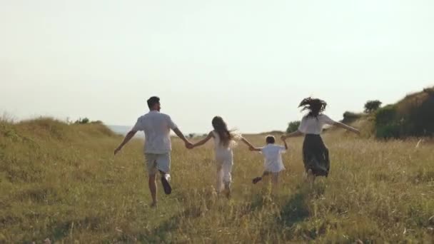 Eltern mit verspielten Kindern laufen gemeinsam durch die Natur — Stockvideo