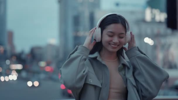 戴着耳机在街上跳舞和走路的快乐女人 — 图库视频影像