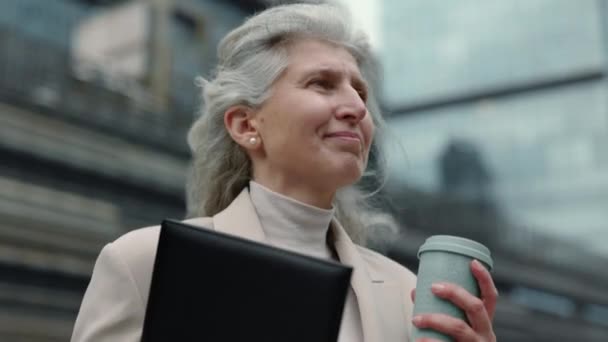 Érett nő írótáblával és kávéval a szabadban — Stock videók