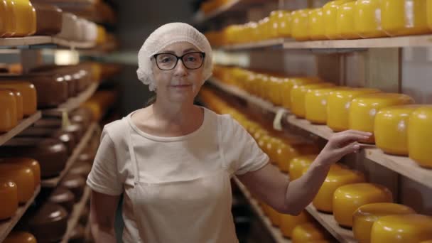 Женщина, изучающая состояние сыра на молочном производстве — стоковое видео