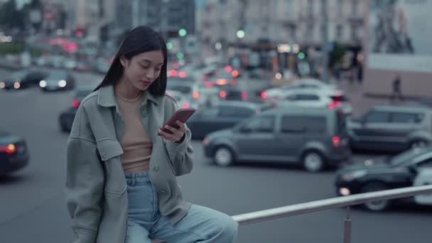 Asiatico donna utilizzando su smartphone schermo su città strada — Video Stock