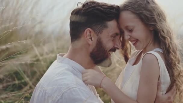 Padre feliz con hija sentada cara a cara en el campo — Vídeo de stock