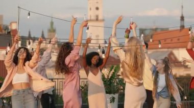 Çeşitli arkadaşlar çatıdaki partide içki ve müzik dinliyorlar.