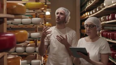 Peynirle depoda duran tabletli mandıra işçileri