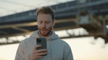 Spor elbiseli adam kardiyo egzersizi sırasında akıllı telefon kullanıyor.