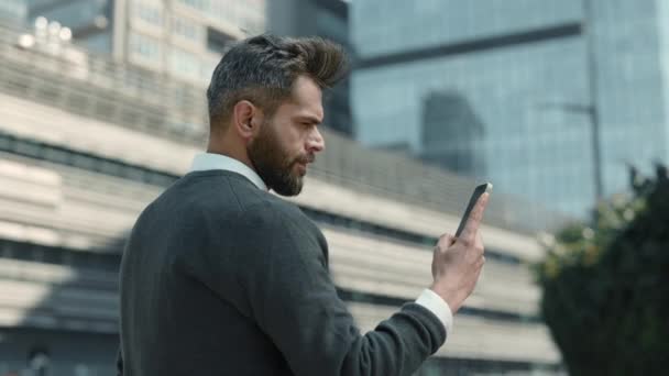 İş adamı dışarıda dururken akıllı telefondan mesaj atıyor. — Stok video
