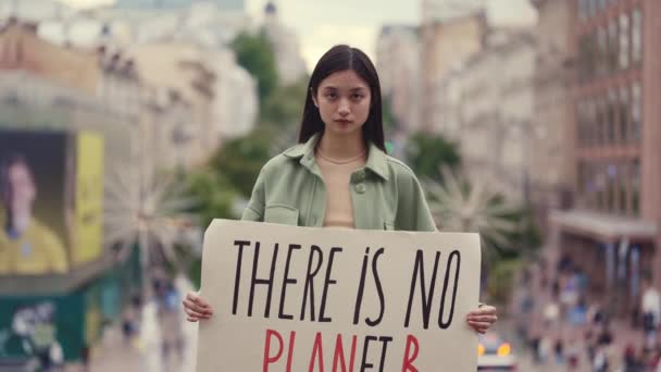 Азійська жінка тримає прапор з виразом "немає планети Б". — стокове відео