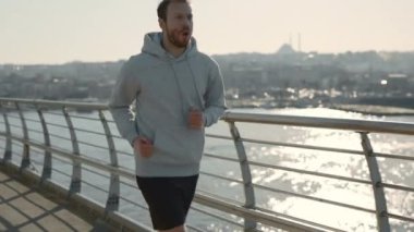 Gün batımında caddede koşan kızıl saçlı adam.