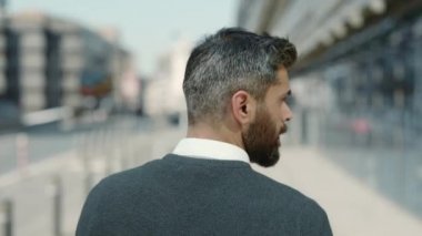 Şehir caddesinde yürüyen şık orta yaşlı bir adam.