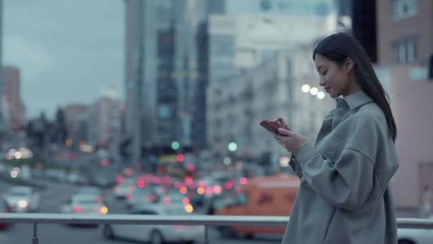 Mulher coreana usando telefone celular enquanto caminha ao ar livre — Vídeo de Stock