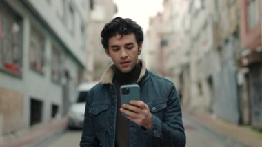 Sokakta yürürken akıllı telefon kullanan Arap turist