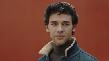 Sokakta dikilirken kameraya bakan Arap adam.