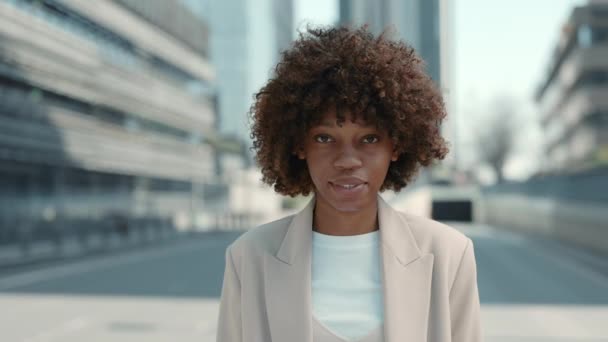 Mujer africana feliz en traje de negocios posando en la calle de la ciudad — Vídeo de stock