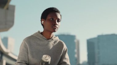 Afro-Amerikalı kadın şehir sokaklarında koştuktan sonra dinleniyor.