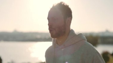 Şehrin caddesinde koşan aktif giyimli güçlü sakallı adam.