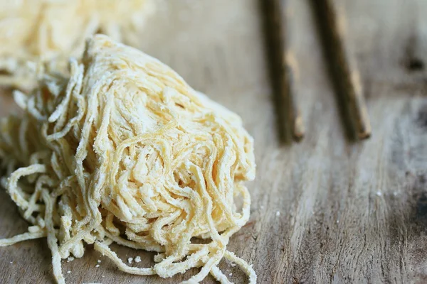 Fideos huevo sobre madera — Foto de Stock