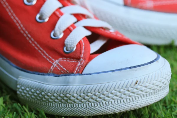 Red sneakers on lawn — Stock Photo, Image