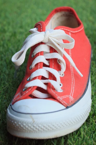 Red sneakers on lawn — Stock Photo, Image