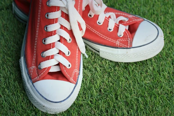 Red sneakers on lawn — Stock Photo, Image