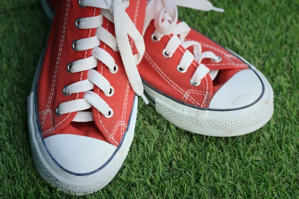 Red sneakers on lawn — Stock Photo, Image