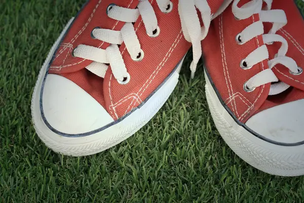 Red sneakers on lawn — Stock Photo, Image