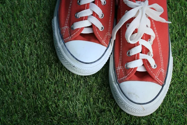 Red sneakers on lawn — Stock Photo, Image