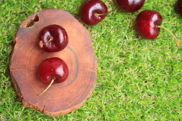 Fresh cherries on green grass — Stock Photo, Image