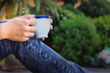 oturan kadın elinde bir fincan kahve