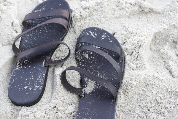 Кожаные сандалии на песке — стоковое фото