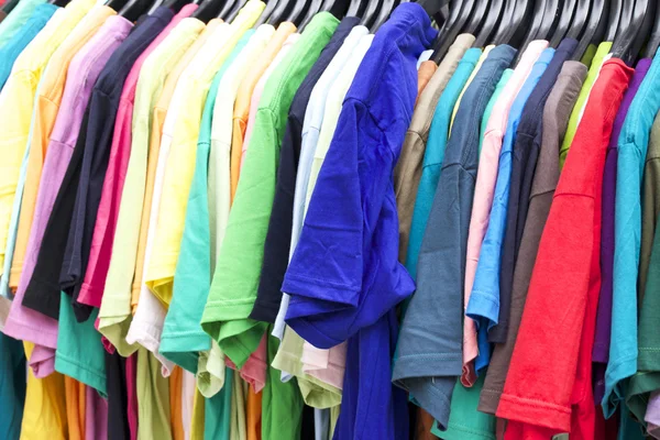 Shop shirts colorful fabric hanging on a rack. — Stock Photo, Image