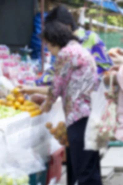 La gente borrosa compra fruta en el mercado . —  Fotos de Stock