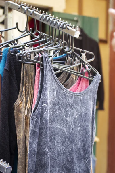 Loja camisas colorido tecido pendurado em um rack . — Fotografia de Stock