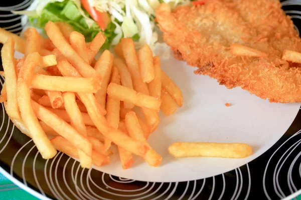 Steaks, french fries with vegetables salad on a plate. — Stock Photo, Image