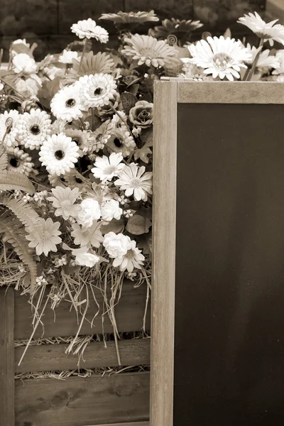 Blackboard en kunstmatige bloemen — Stockfoto