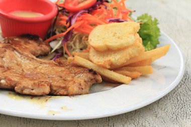 Domuz pirzolası, kızarmış patates salatası ile