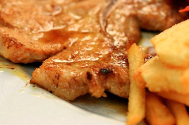 Domuz pirzolası, kızarmış patates salatası ile