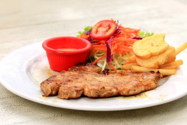 Domuz pirzolası, kızarmış patates salatası ile