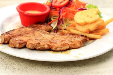 Domuz pirzolası, kızarmış patates salatası ile