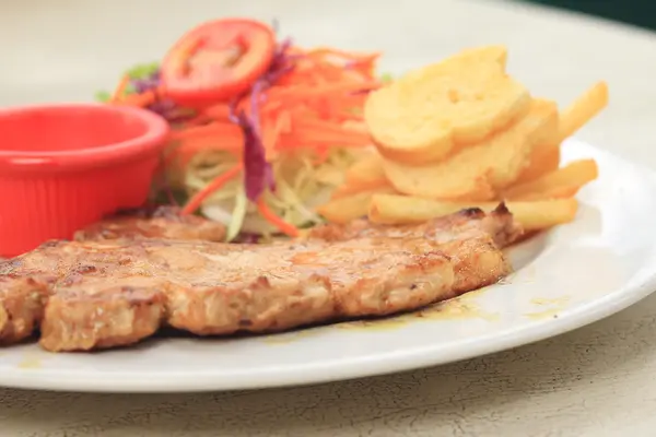 Costeleta de porco, batatas fritas com salada — Fotografia de Stock