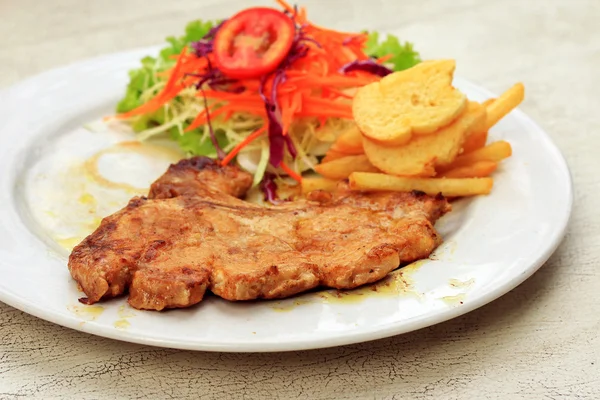 Chuleta de cerdo, papas fritas con ensalada —  Fotos de Stock