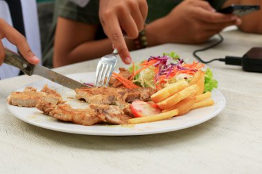 Domuz pirzolası, kızarmış patates salatası ile