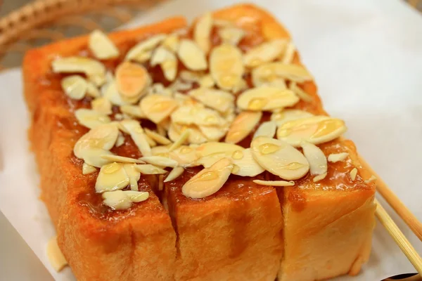 Toast brood gegarneerd met honing en amandel. — Stockfoto