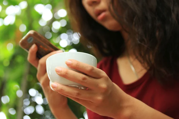 Размытая женщина с помощью смартфонов и кофе . — стоковое фото
