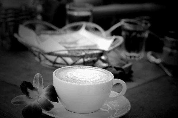 Vintage Latte Art Kaffee und rosa Orchidee — Stockfoto