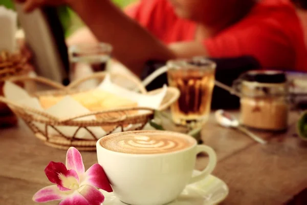 Vintage latte art kávé és rózsaszín orchidea — Stock Fotó