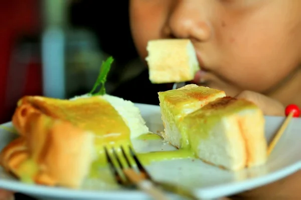 Kinderen eten toast gegarneerd met vla en slagroom. — Stockfoto