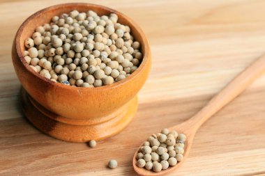 ahşap arka plan üzerinde beyaz biber tohumları.