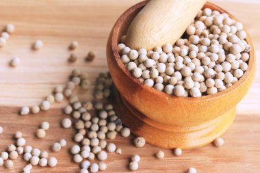 ahşap arka plan üzerinde beyaz biber tohumları.