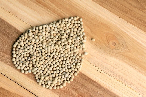 Семена белого перца на деревянном фоне . — стоковое фото